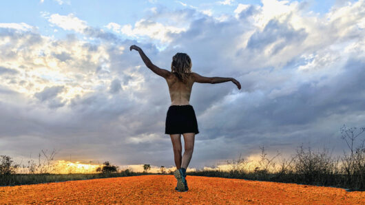 De kleur Oranje - vrouw wandelend in het avondrood