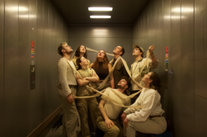 Road to Nowhere ArtEZ foto met 8 jonge mensen in een lift met witte kleding aan verbonden door een lint