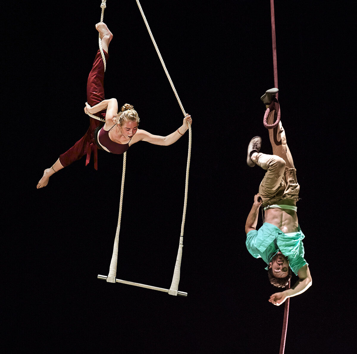 circusvoorstelling PLOF!, luchtacrobate en accordeonspeler in de trapeze